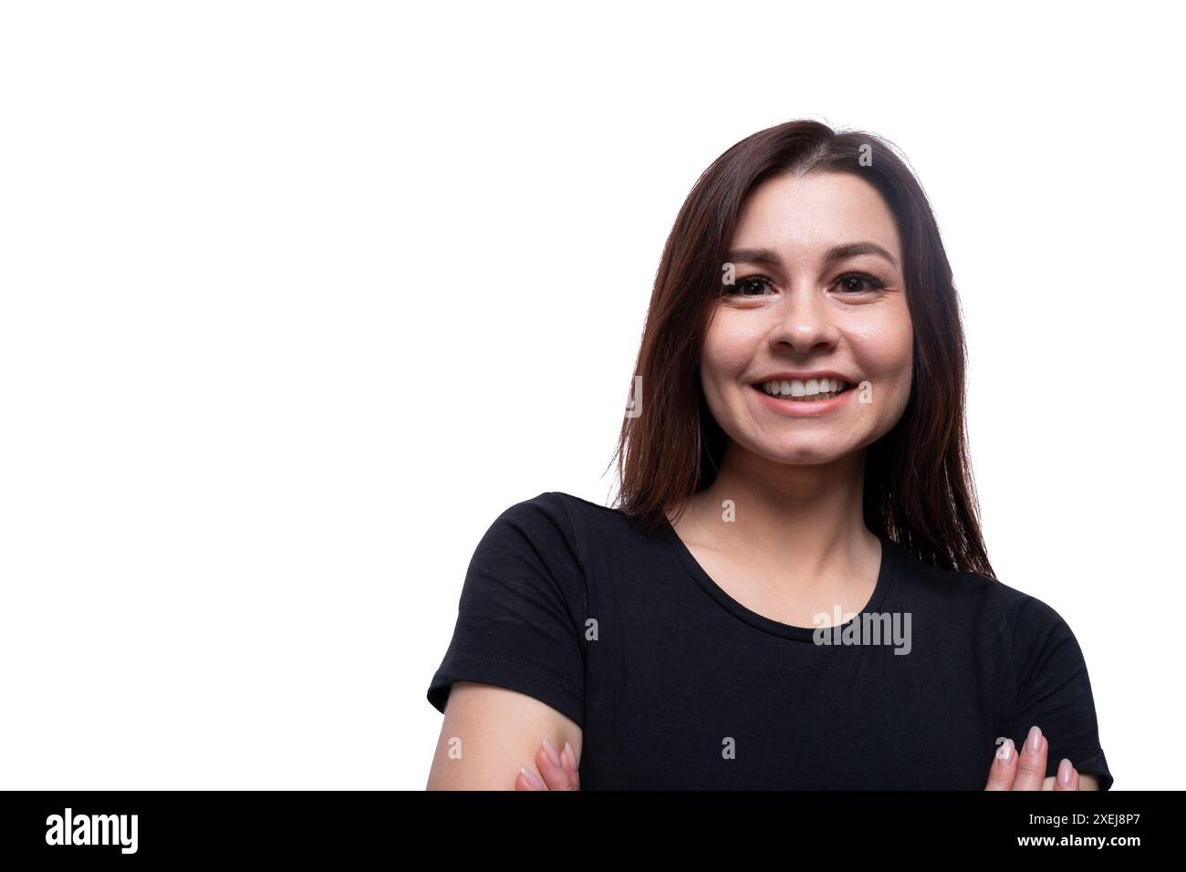 Young friendly woman with black hair wearing a black T-shirt on a white background with copy space Stock Photo