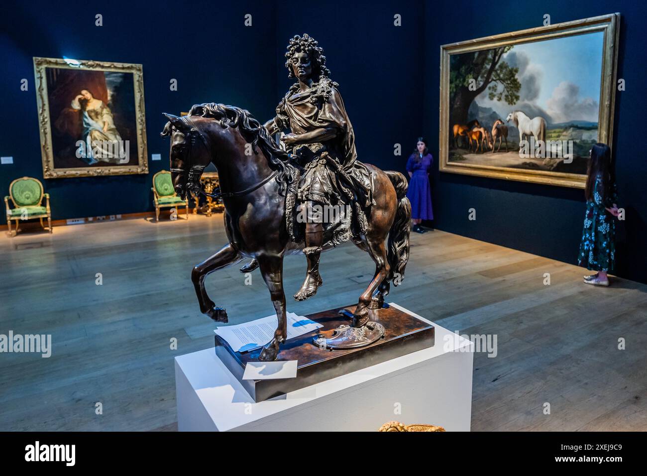 London, UK. 28th June, 2024. After Francois Girardon, Late 19th Century, Louis XIV on Horse, Estimate GBP 15,000 – GBP 25,000 with George Stubbs's celebrated Mares and Foals paintings (estimate: £7,000,000-10,000,000) in the background - Christie's Classic Week sales. Spanning art from antiquity to the 20th century, with six live auctions, the series will run from 2 to 10 July, with auction highlights on public view from 28 June. Credit: Guy Bell/Alamy Live News Stock Photo