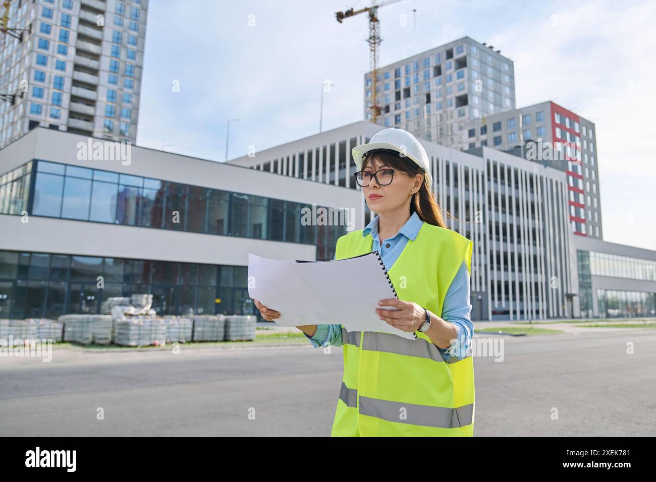 Industrial worker female builder with working documents, outdoor construction Stock Photo