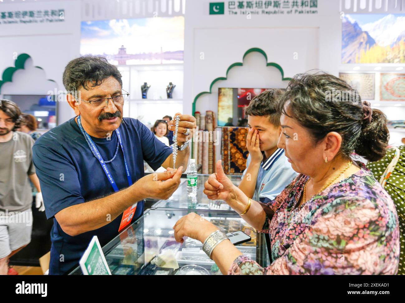 (240628) -- URUMQI, June 28, 2024 (Xinhua) -- Visitors select jewelry at the booth of Pakistan during the 8th China-Eurasia Expo in Urumqi, northwest China's Xinjiang Uygur Autonomous Region, June 27, 2024. Businessmen from many parts of the world have gathered in northwest China's Xinjiang, displaying exquisite goods such as French wine, Serbian coffee, Australian chocolate and Ghanaian drums. The 8th China-Eurasia Expo, held at the Xinjiang International Convention and Exhibition Center at the foot of the Tianshan Mountains, commenced Wednesday in the regional capital of Urumqi. Themed Stock Photo