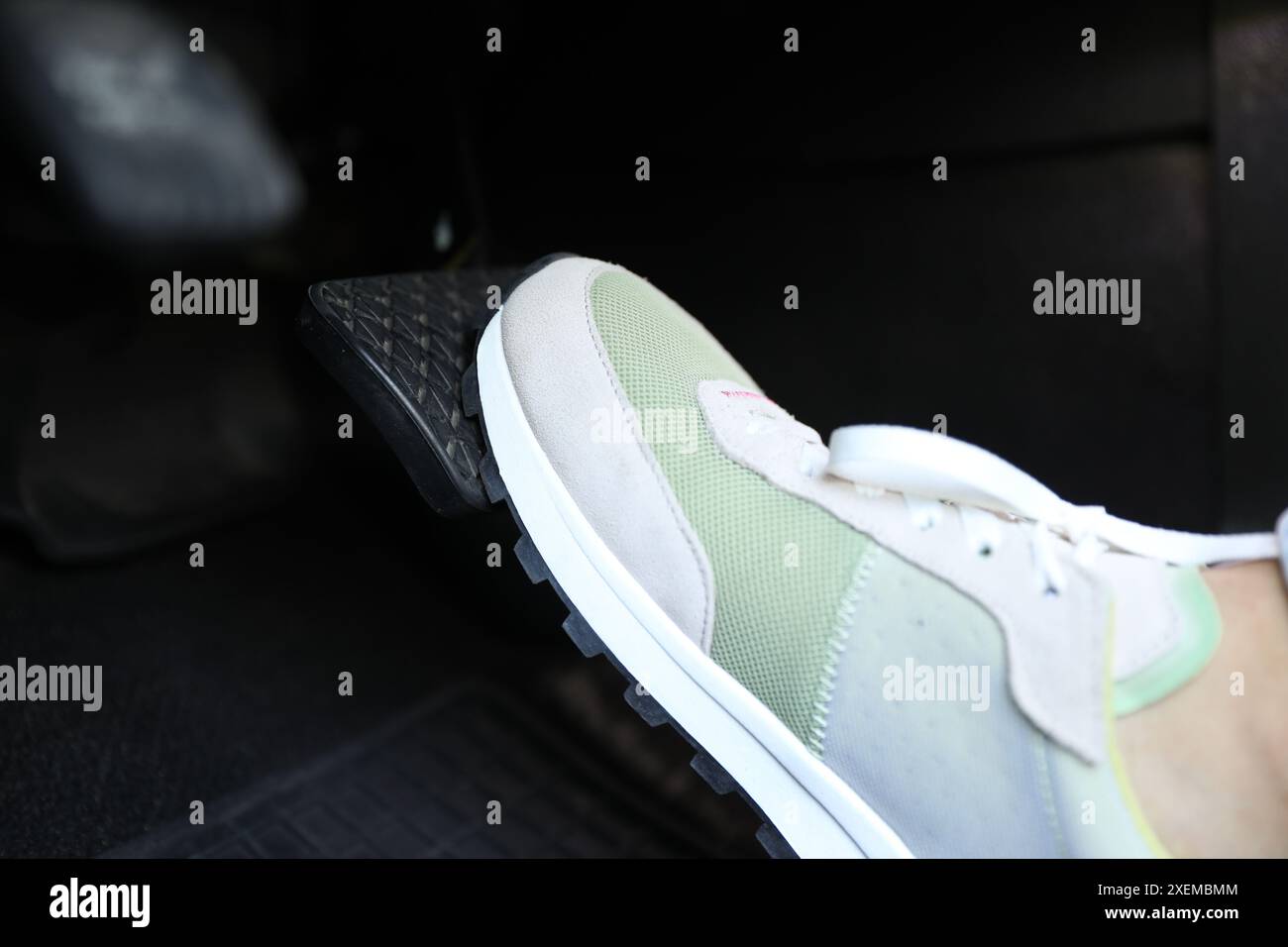 Woman pushing on pedal of car brake, closeup Stock Photo