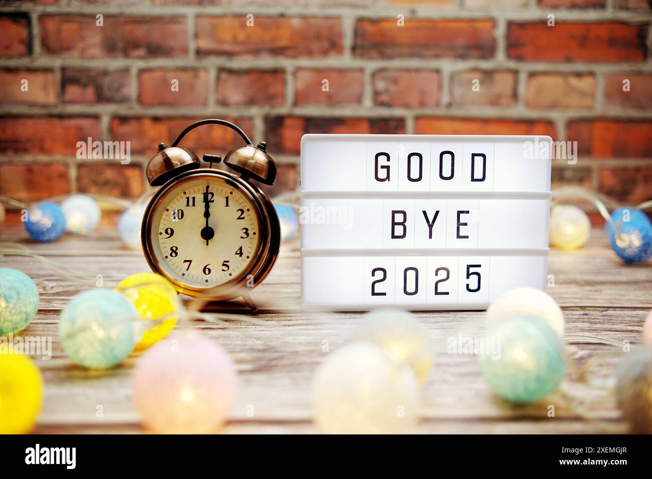 Goodbye 2025 text in light box with alarm clock and LED cotton balls