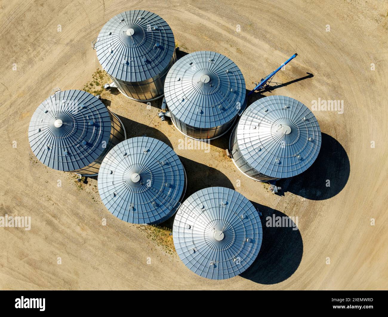 Overhead aerial view of large metal grain bins on farmland North of Calgary, Alberta; Alberta, Canada Stock Photo