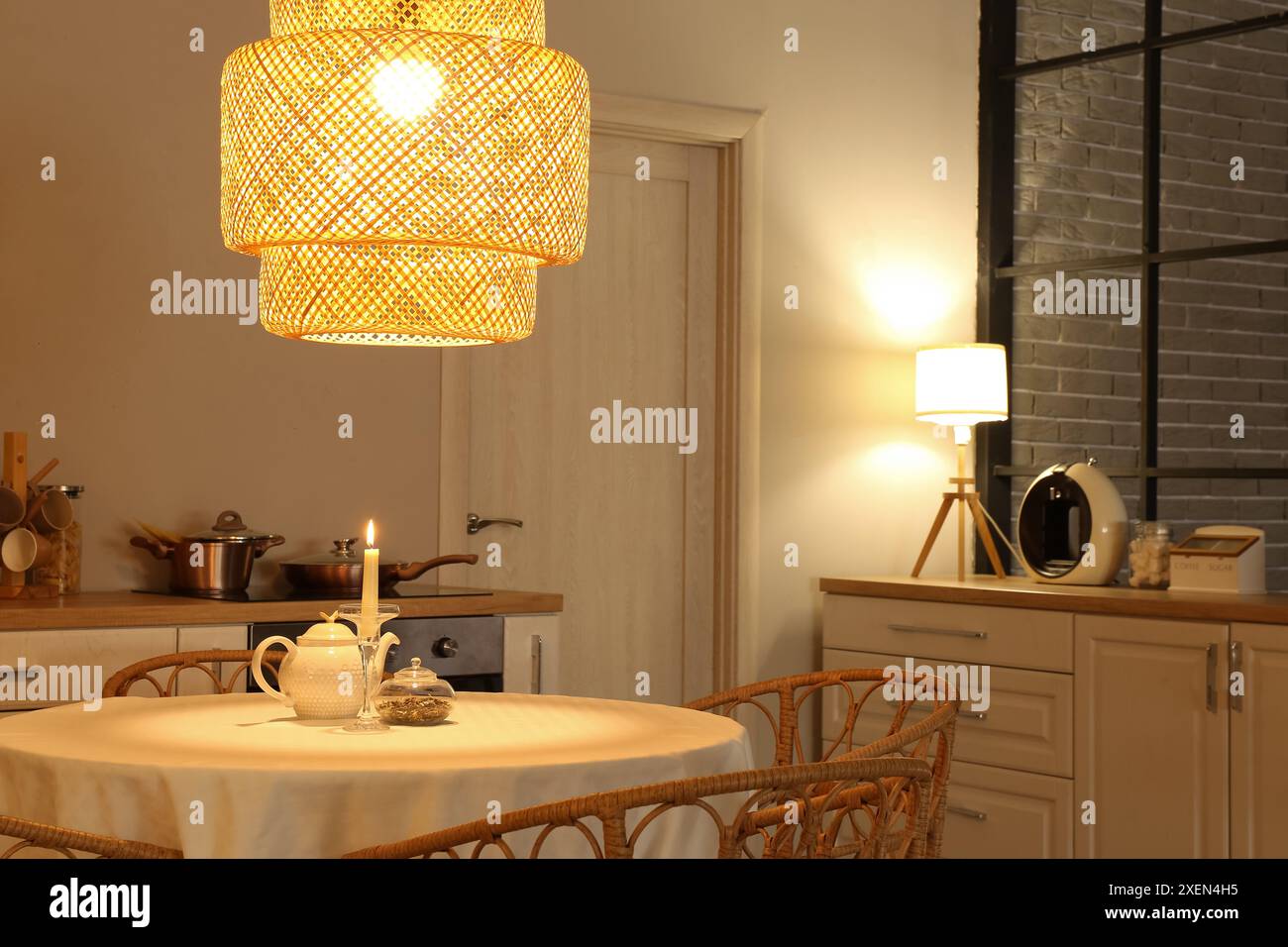 Interior of modern kitchen with glowing lamps, white counters and ...