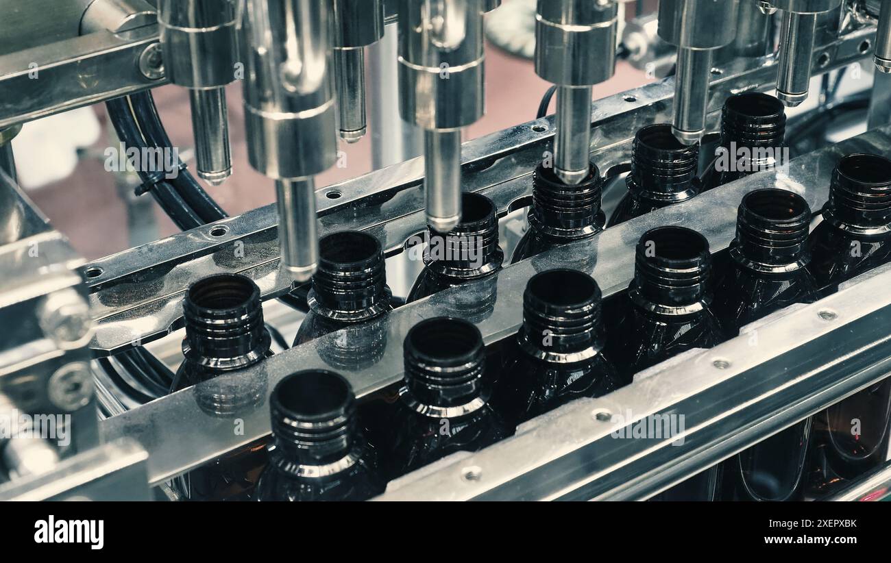 Bottles filling automation machine in modern factory. Technology ...