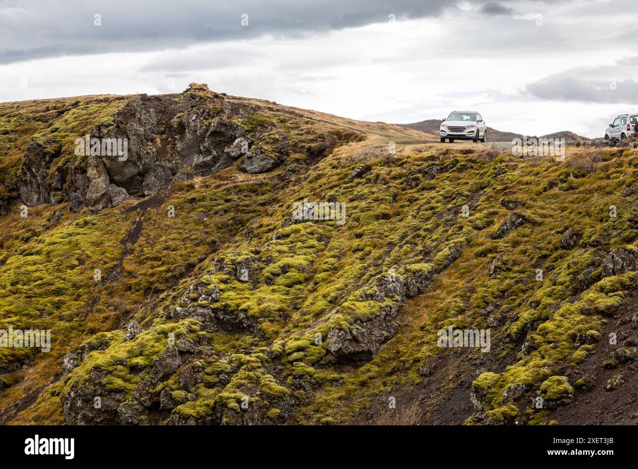 Off-road car parked at the edge of the volcanic cliff overgrown with moss in Gjain canyon, Thjorsardalur valley, South Iceland. Stock Photo