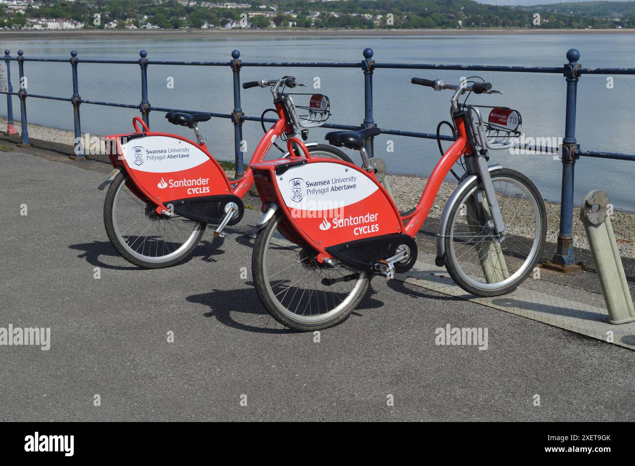 Two Santander Cycles parked up by the promenade railings in Mumbles. Swansea, Wales, United Kingdom. 16th May 2024. Stock Photo