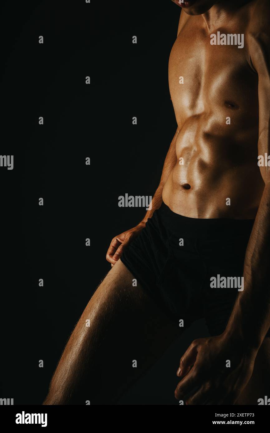 Fit Man Showing His Abs In A Dark Background With Defined Muscles And fit-man-showing-his-abs-in-a-dark-background-with-defined-muscles-and