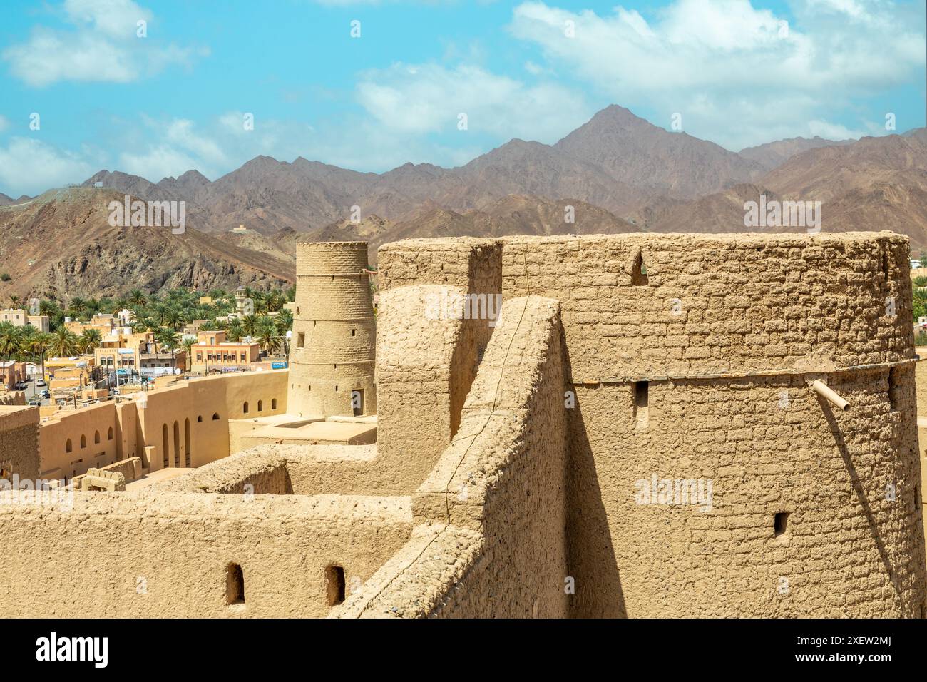 Bahla citadel fortress stone walls and round towers with mountains in ...