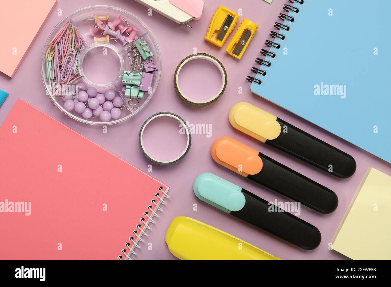 Flat lay composition with notebooks and different stationery on violet background Stock Photo