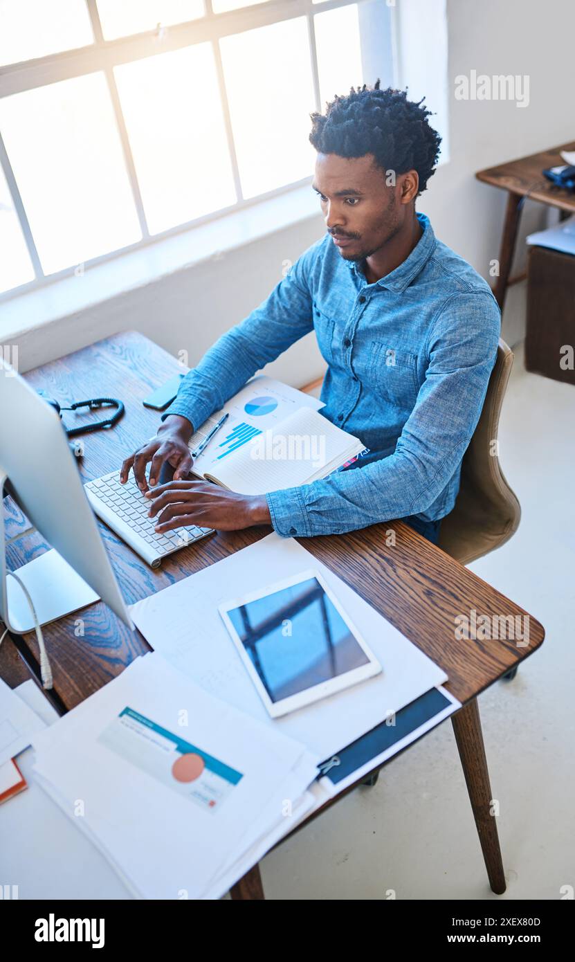 Computer, typing and black man in office, charts and research of ...