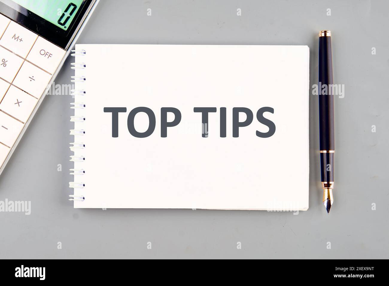 The phrase Top Tips in a notebook on a gray background Stock Photo