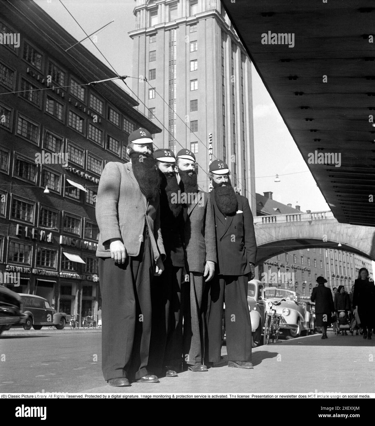 In the 1940s. A group of four men all wearing fake beard in the street ...