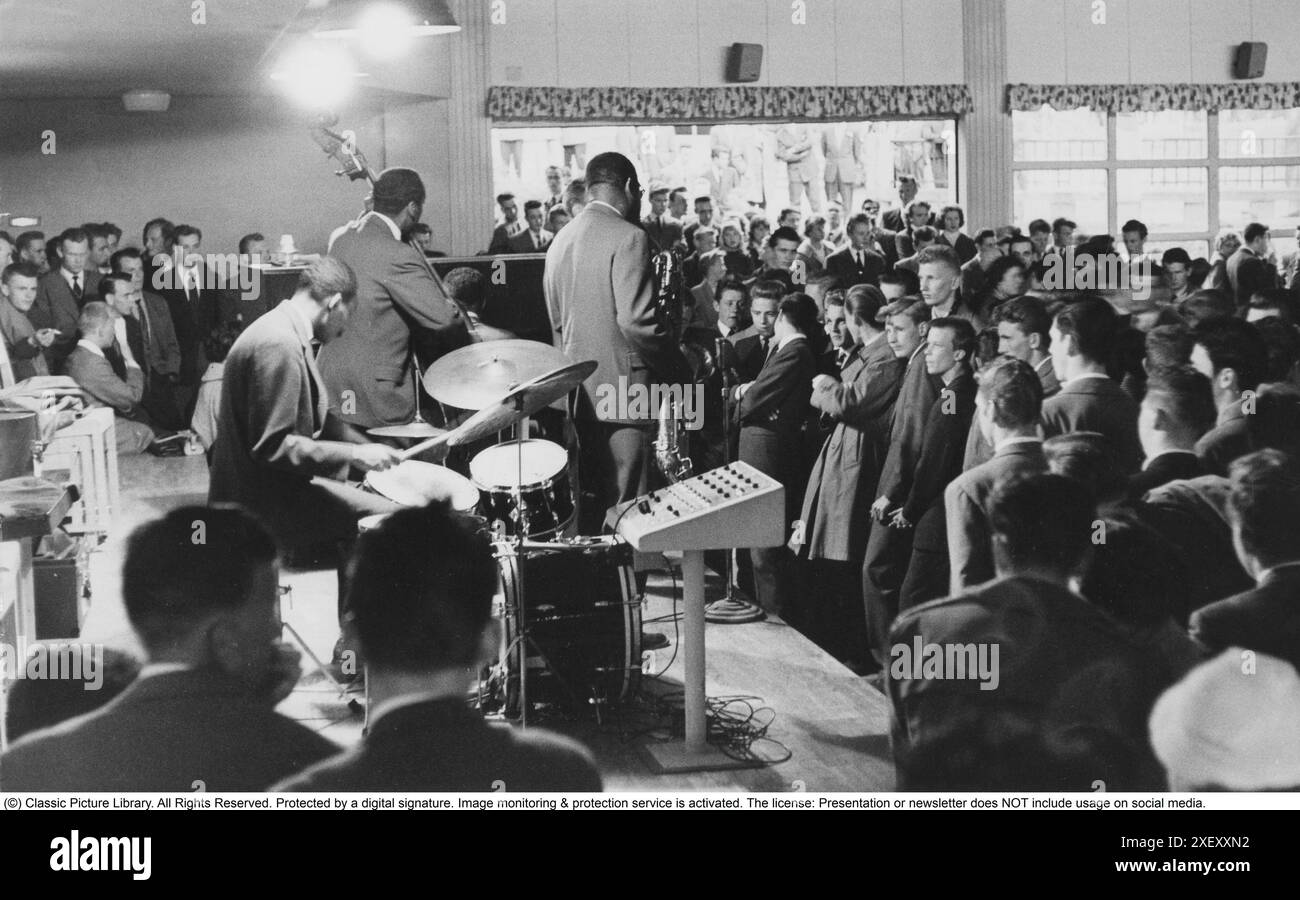Jazz in the 1950s. A jazz orchestra on stage playing jazz for an audience in the evening. It's a foreign band touring Sweden and is seen performing at Eskilstuna Folkets park in august 1956. Stock Photo