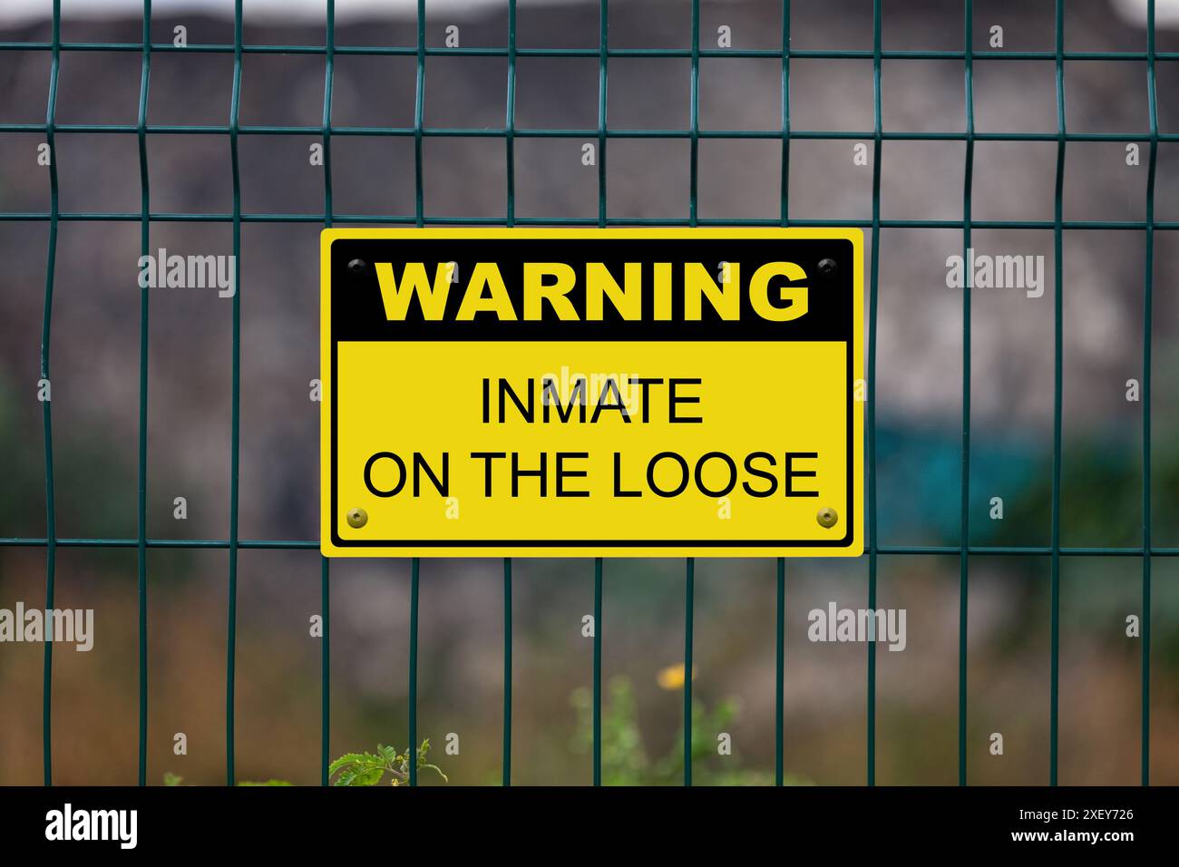 Black and Yellow warning sign attached on a fence. The sign stating