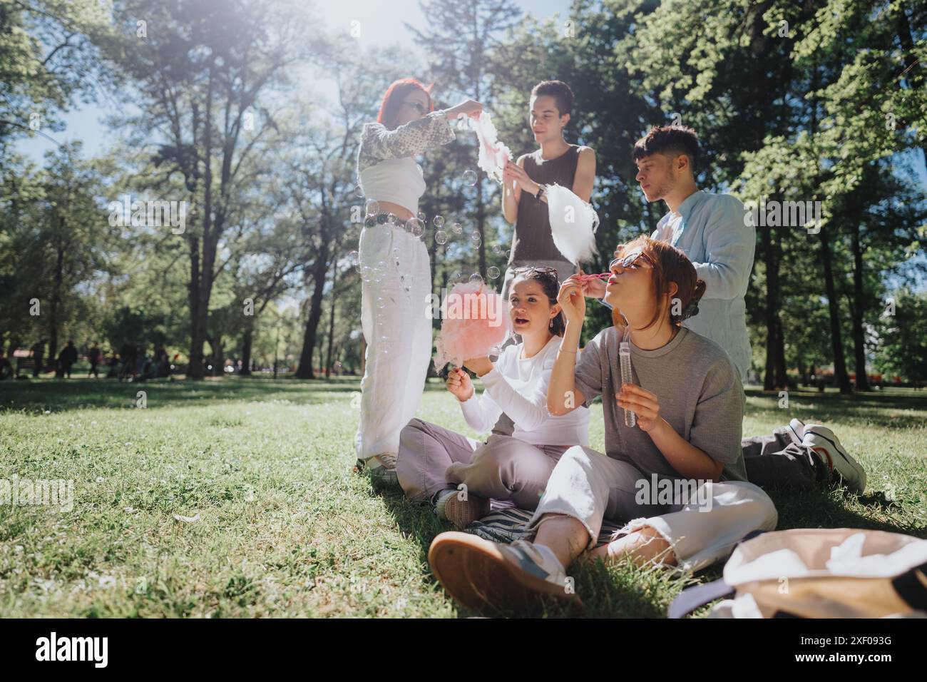 Friends enjoying a sunny day at the park with bubbles and cotton candy ...