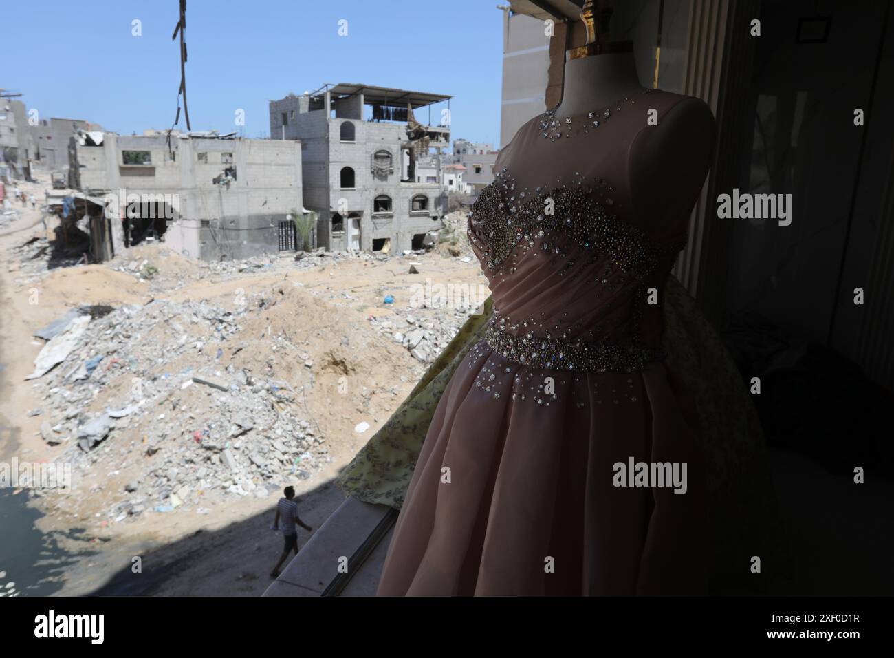 Khan Yunis, Palestinian Territories. 30th June, 2024. Palestinian Faten Abu Ghraib, owner of a shop that rents bridal costumes, returns to open her shop in the devastated area after the Israeli army invaded and completely destroyed the neighborhood, during the fierce battles between Israel and Hamas. Faten Abu Ghraib opens her store for the first time since the Israeli army's withdrawal in the city of Khan Yunis. Credit: Abed Rahim Khatib/dpa/Alamy Live News Stock Photo