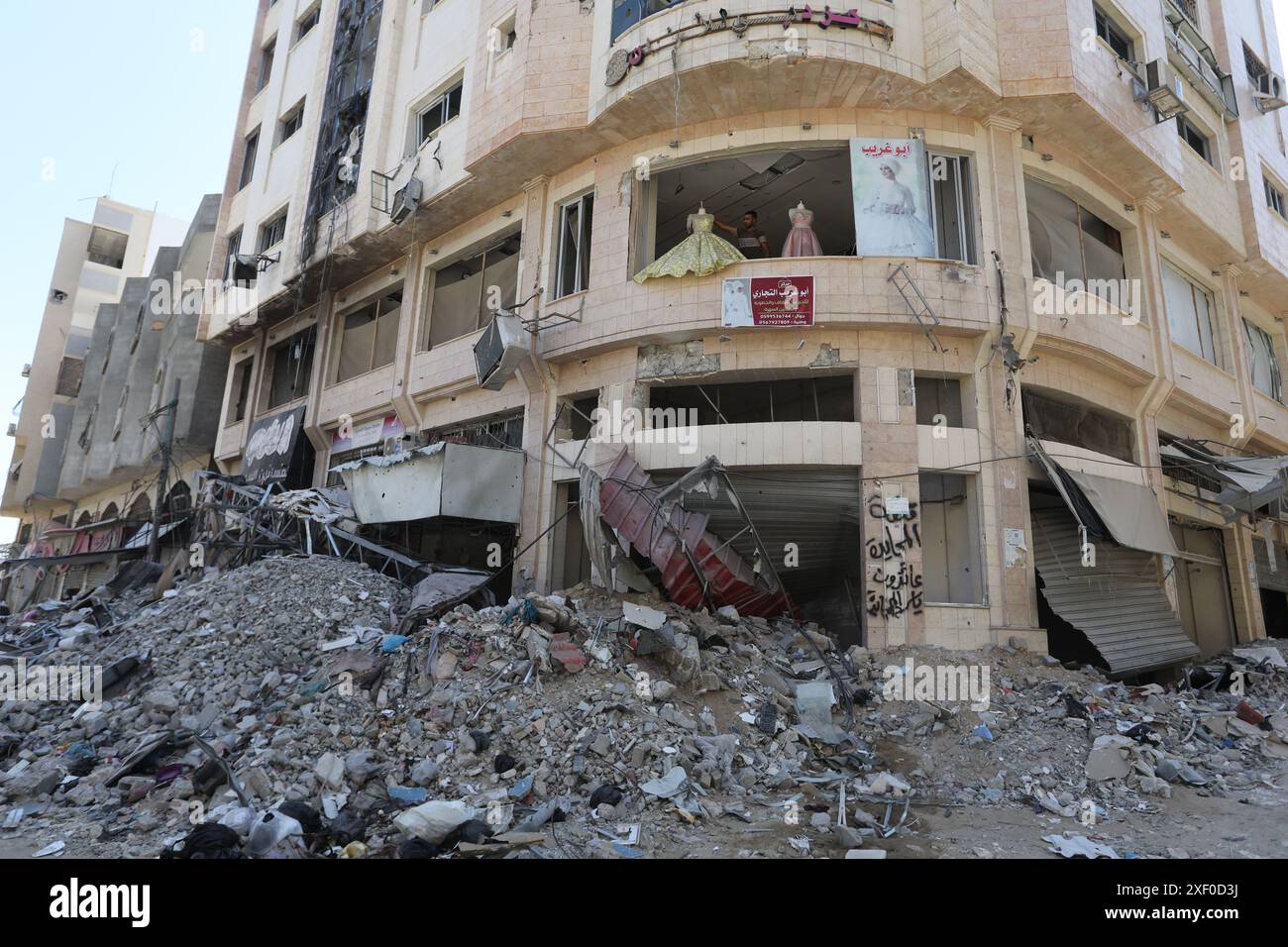 Khan Yunis, Palestinian Territories. 30th June, 2024. Palestinian Faten Abu Ghraib, owner of a shop that rents bridal costumes, returns to open her shop in the devastated area after the Israeli army invaded and completely destroyed the neighborhood, during the fierce battles between Israel and Hamas. Faten Abu Ghraib opens her store for the first time since the Israeli army's withdrawal in the city of Khan Yunis. Credit: Abed Rahim Khatib/dpa/Alamy Live News Stock Photo