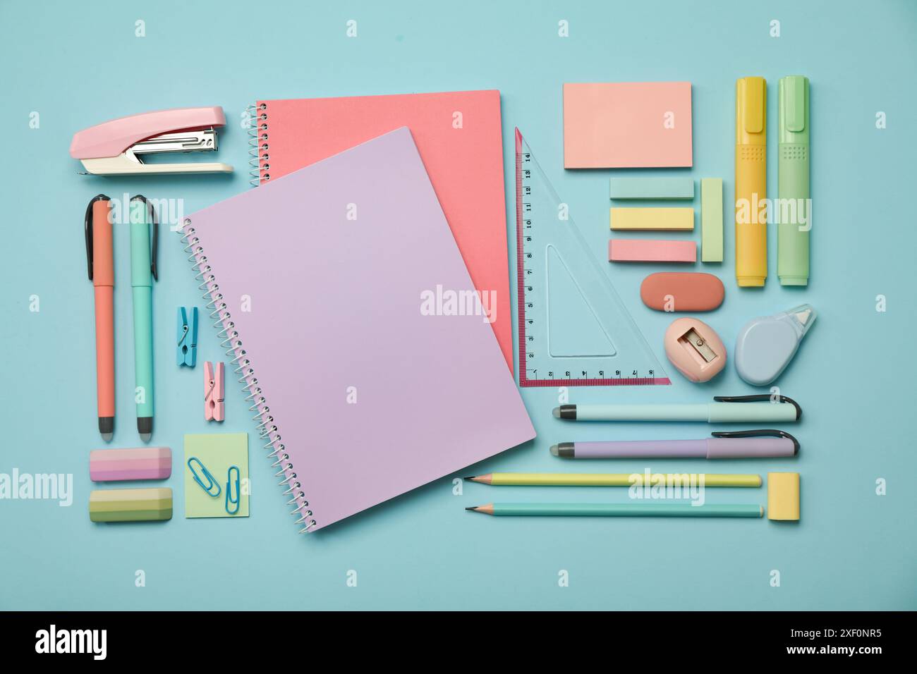 Flat lay composition with notebooks, stapler and different stationery on light blue background Stock Photo