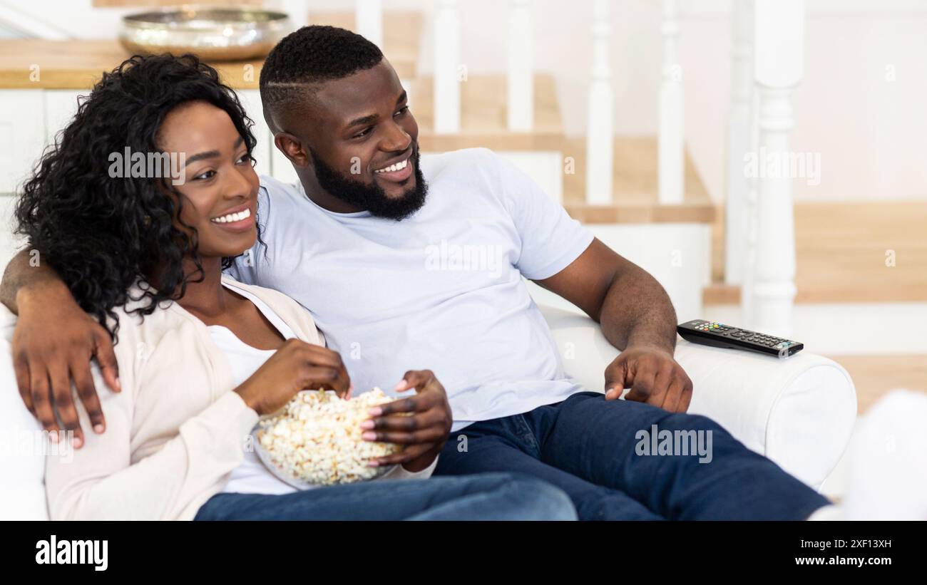 Couple Relaxing On Couch With Popcorn Stock Photo