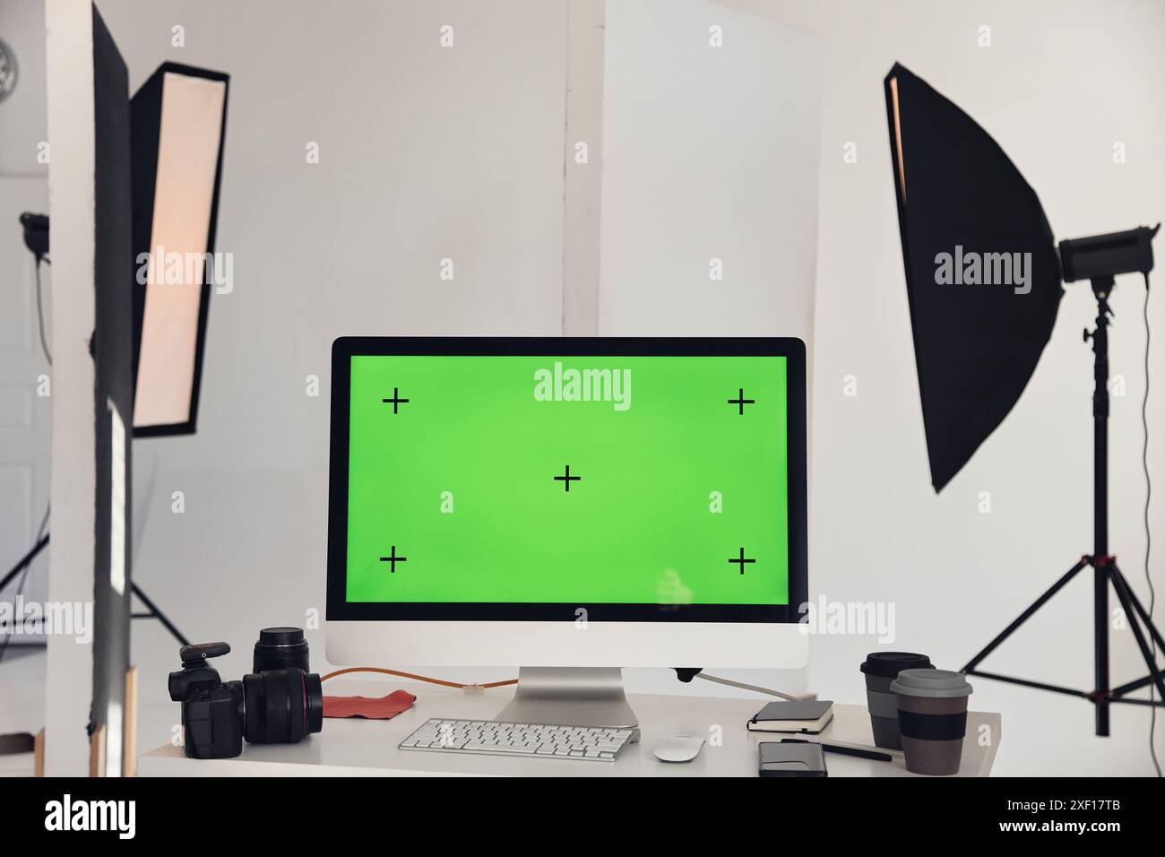 Minimal background image of computer with chroma key green screen on workplace table in photo studio with professional lighting equipment, copy space  Stock Photo