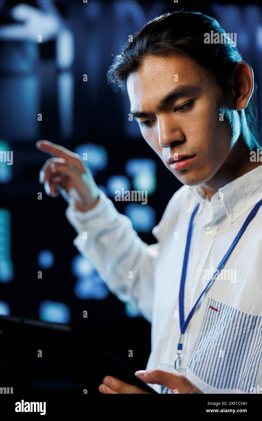 Tech support worker between server cabinets electronics providing processing resources for companies worldwide. Competent developer fixes facility supercomputers used for storing large databases Stock Photo