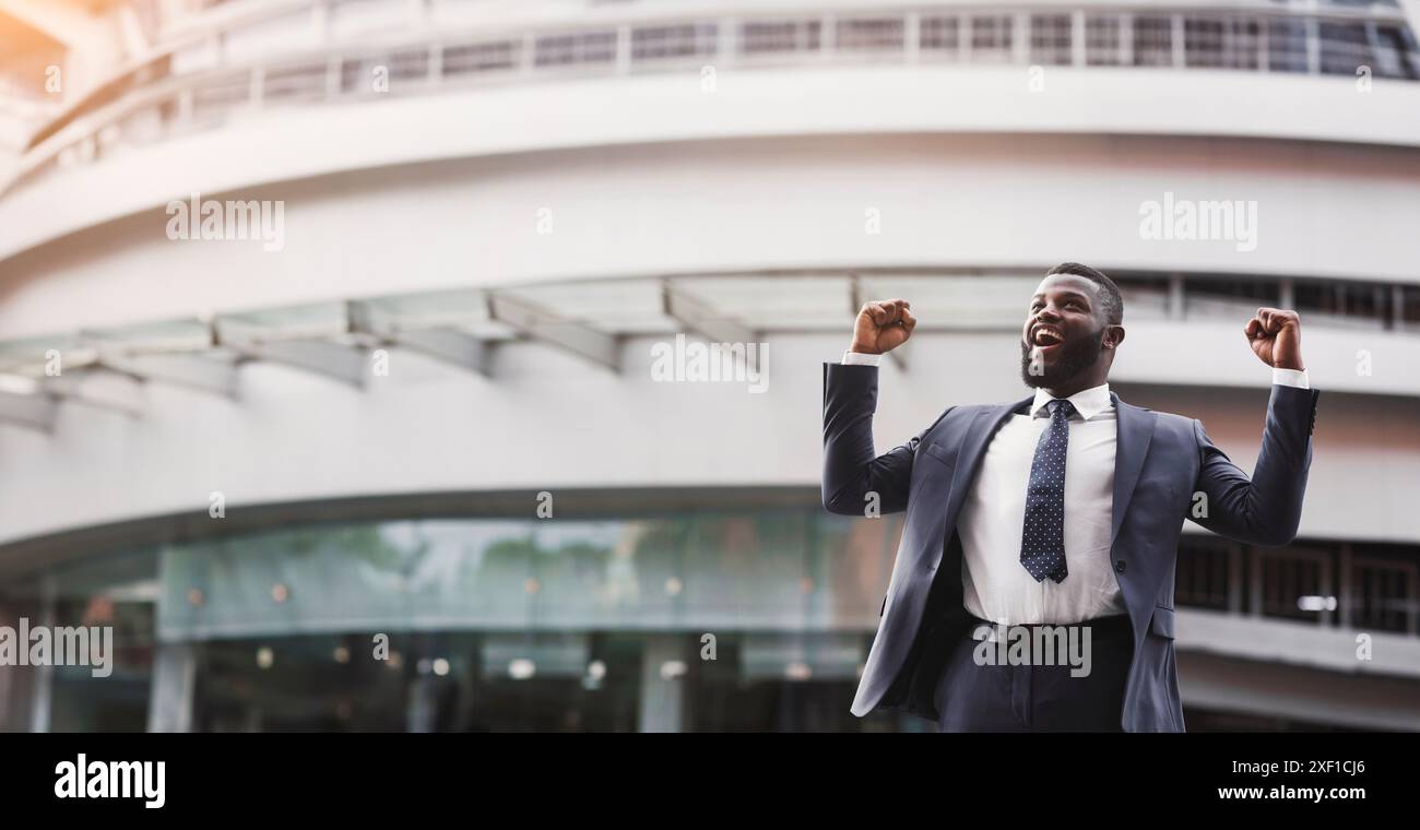 Happy black businessman celebrate victory with fists raised in air ...