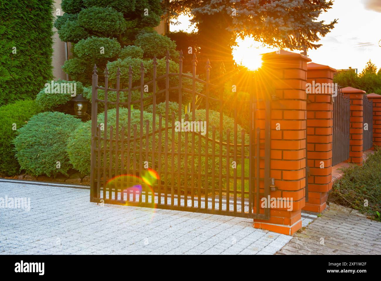 Open gates of brick fence with iron railing outdoors Stock Photo - Alamy