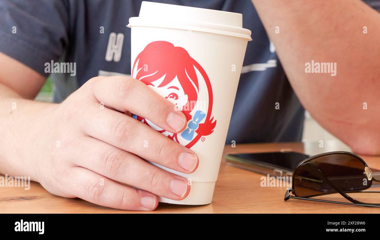 Wendys Fast food Clear plastic cup with red soda on wooden table with ...