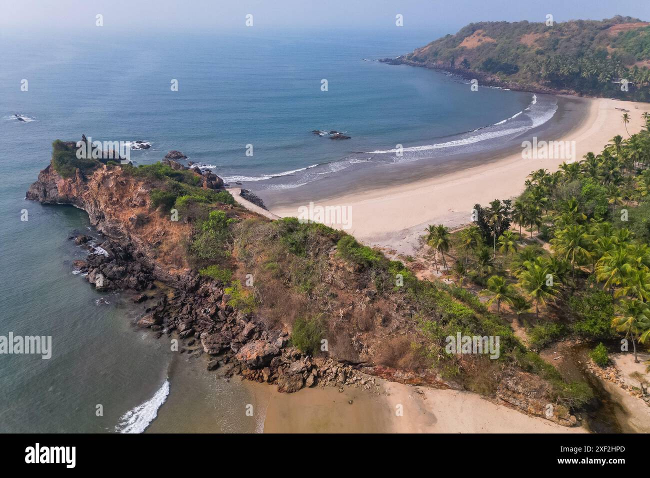 Goa View Aerial top view on tropical beach with green palm trees under sunlight ...