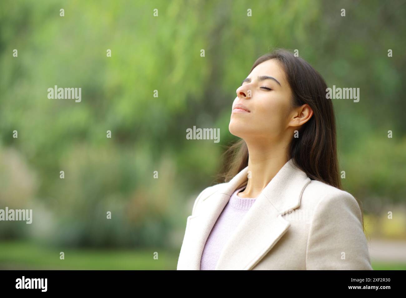 Relaxed woman breathing fresh air in a park in winter season Stock ...