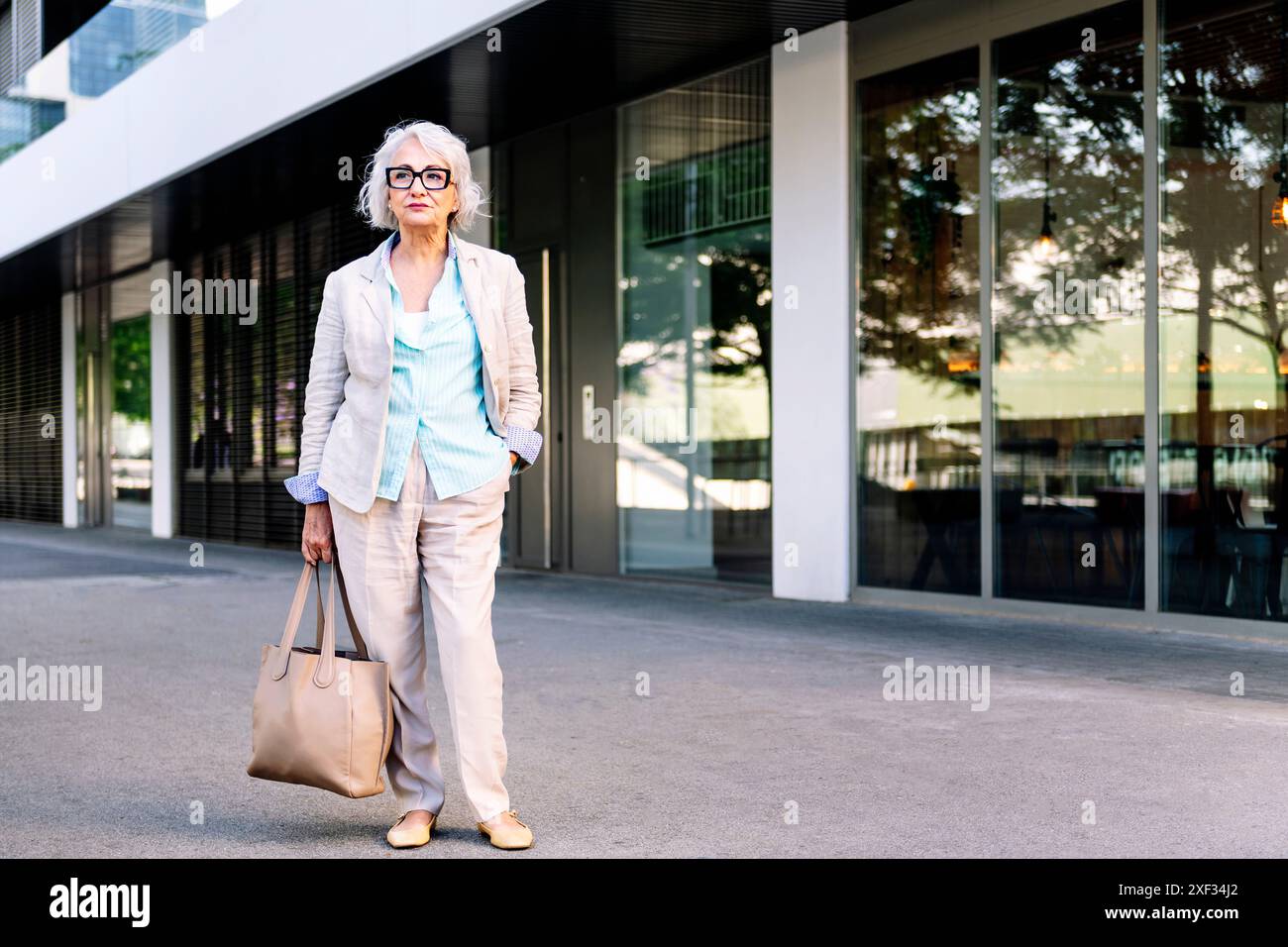 stylish mature woman standing next to a building Stock Photo - Alamy