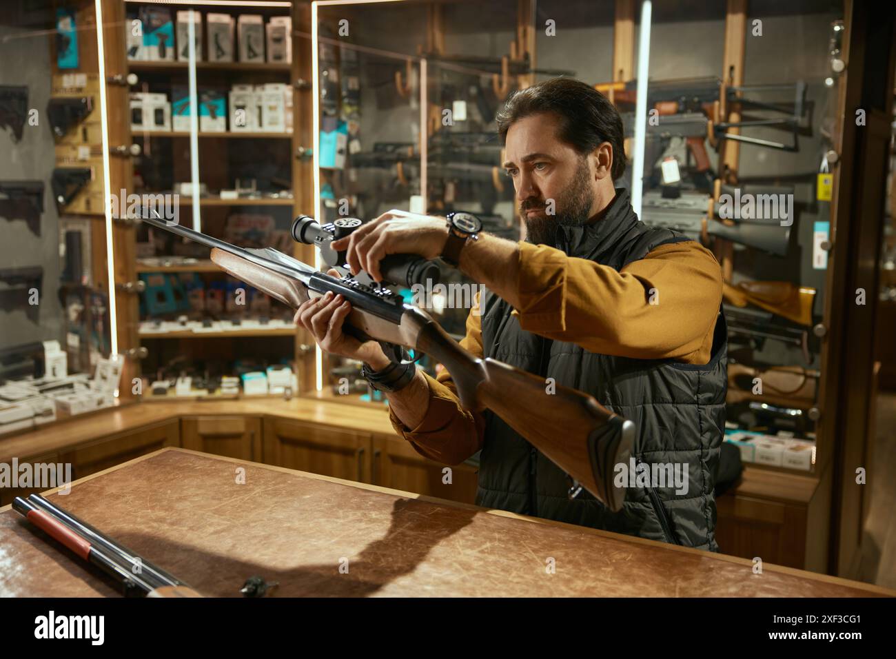 Salesman demonstrating professional accuracy gun assembly at counter desk Stock Photo
