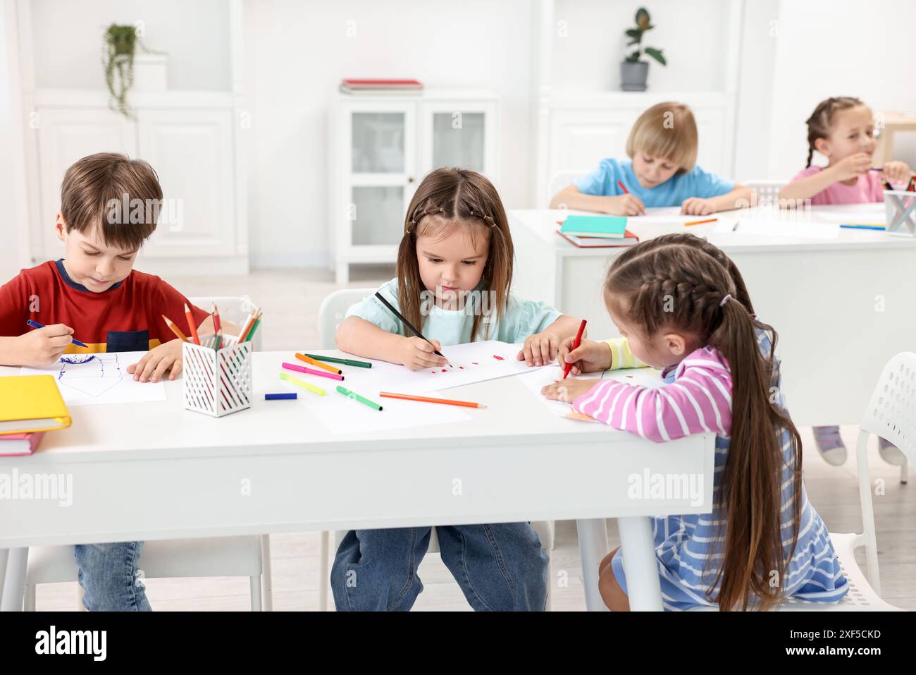Group of children drawing at table indoors Stock Photo - Alamy