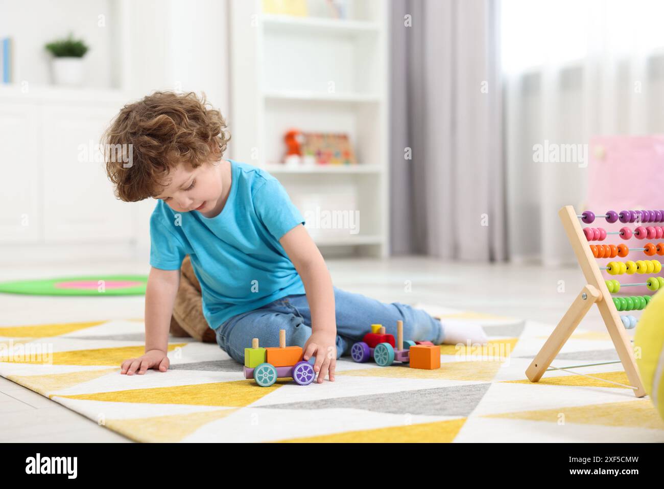 Cute little boy playing with toy cars on floor in kindergarten Stock ...