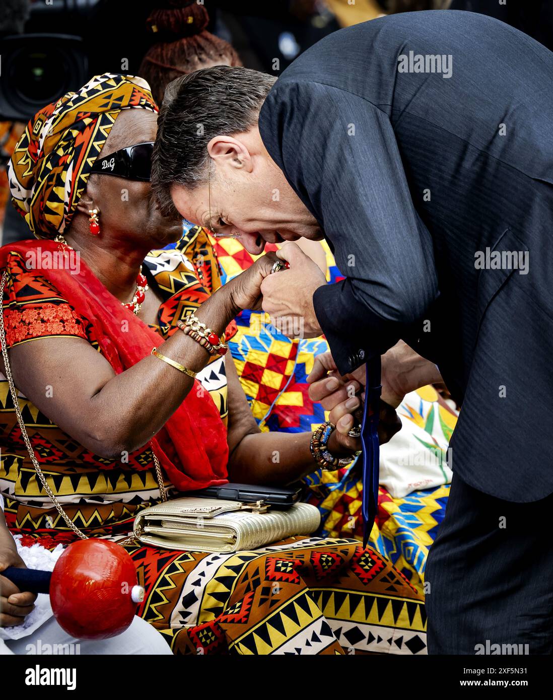 AMSTERDAM - Outgoing Prime Minister Mark Rutte gives a kiss on the hand during the national commemoration of the abolition of slavery at the slavery monument in the Oosterpark. The commemoration is organized by the National Institute for the Dutch Slavery History and Legacy (NiNsee). ANP ROBIN VAN LONKHUIJSEN netherlands out - belgium out Stock Photo
