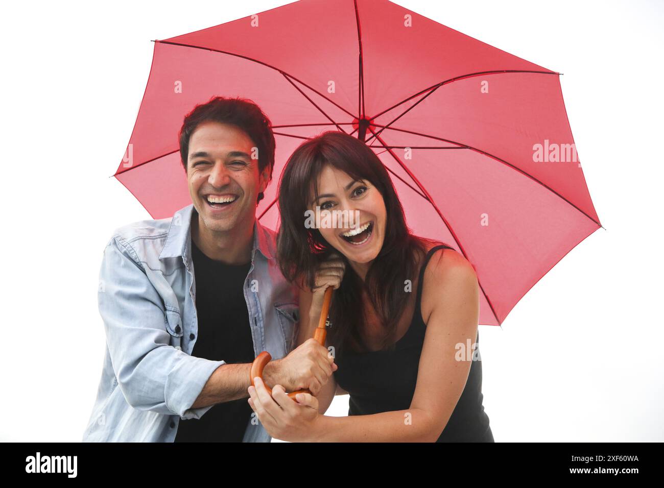 Couple in their 30´s smiling under umbrella Stock Photo - Alamy