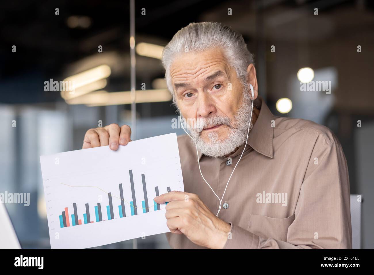 Senior businessman presenting a graph chart during a meeting in a ...