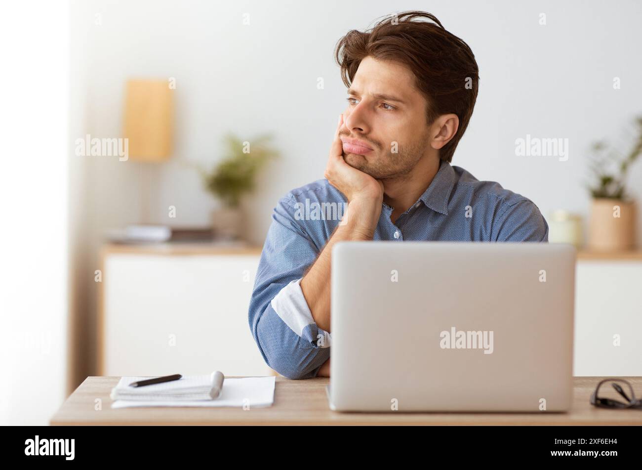 Man Thinking at Desk With Laptop Stock Photo