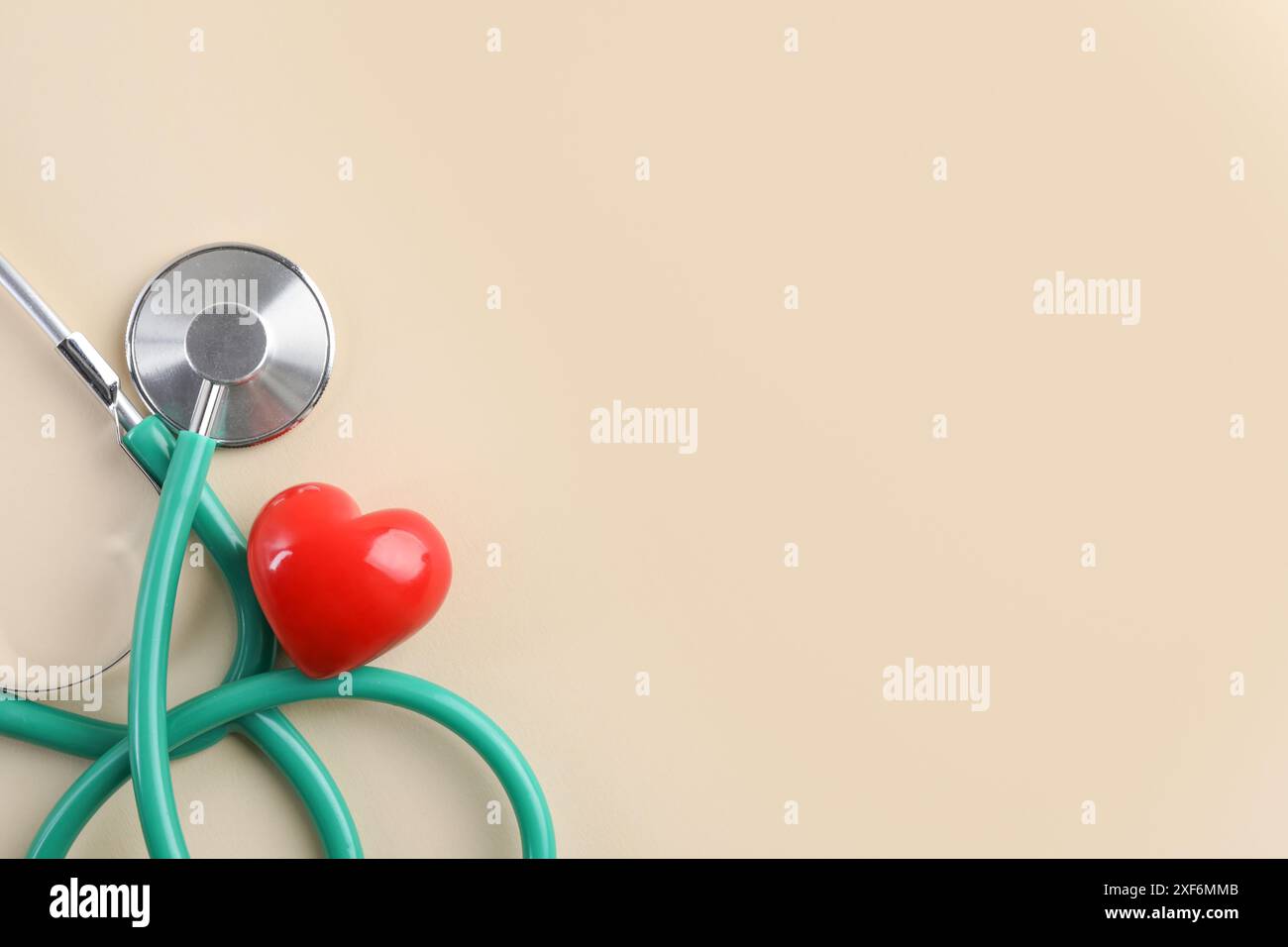 Stethoscope and red heart on beige background, top view. Space for text ...