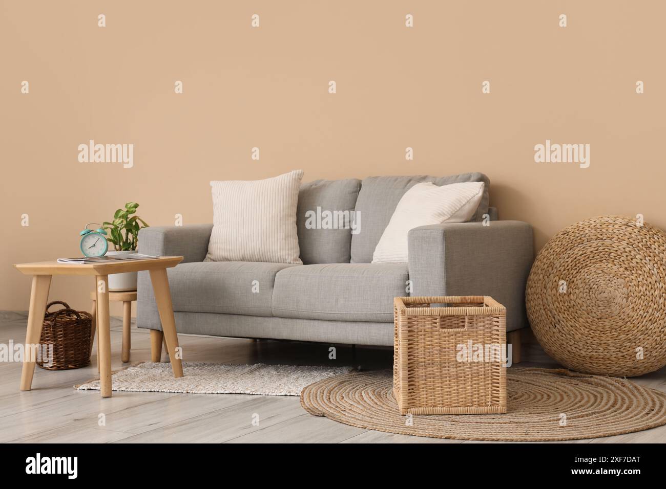 Interior of living room with grey sofa, table and baskets Stock Photo ...