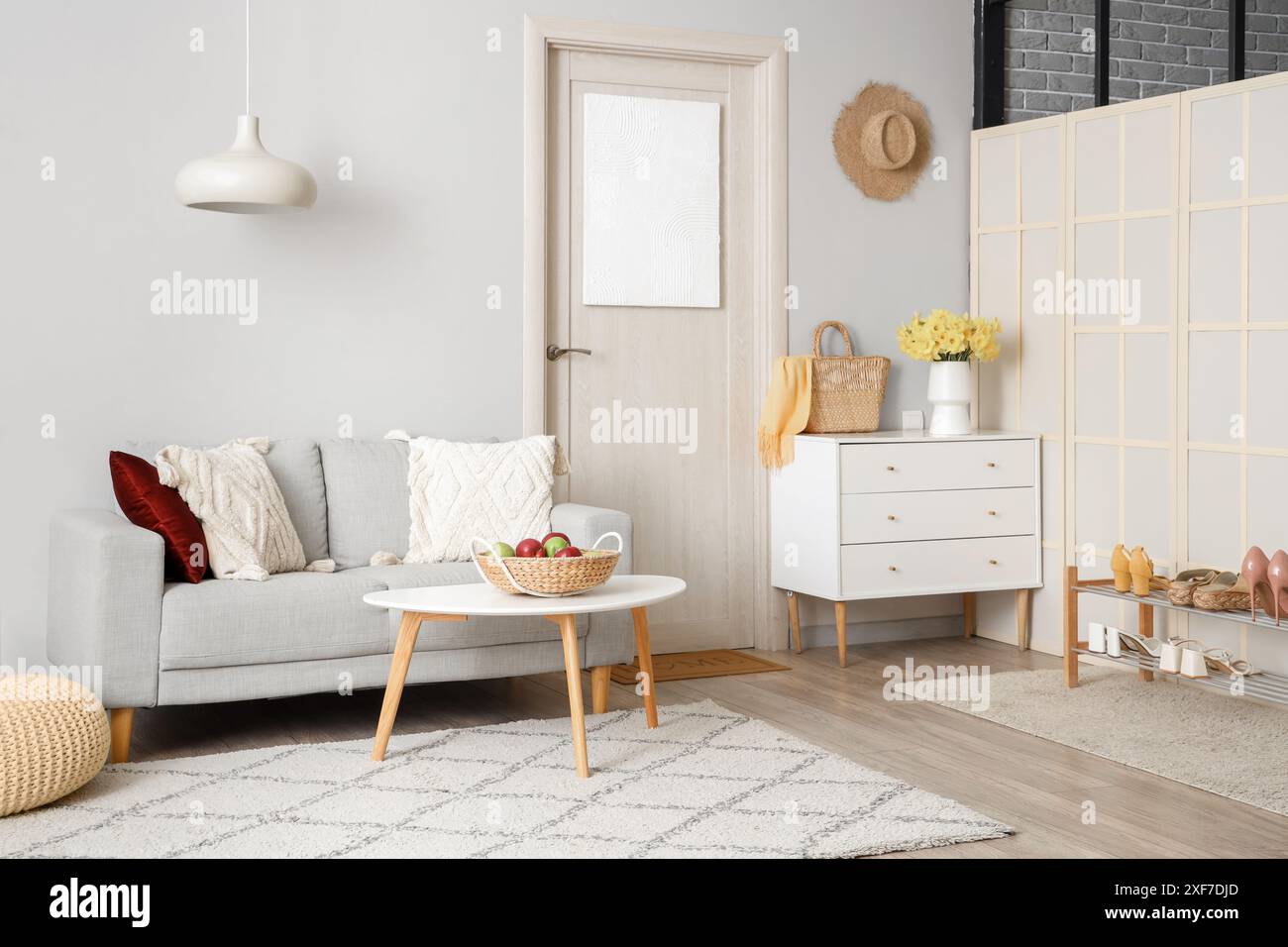 Stylish interior of hall with cozy sofa, chest of drawers and door ...
