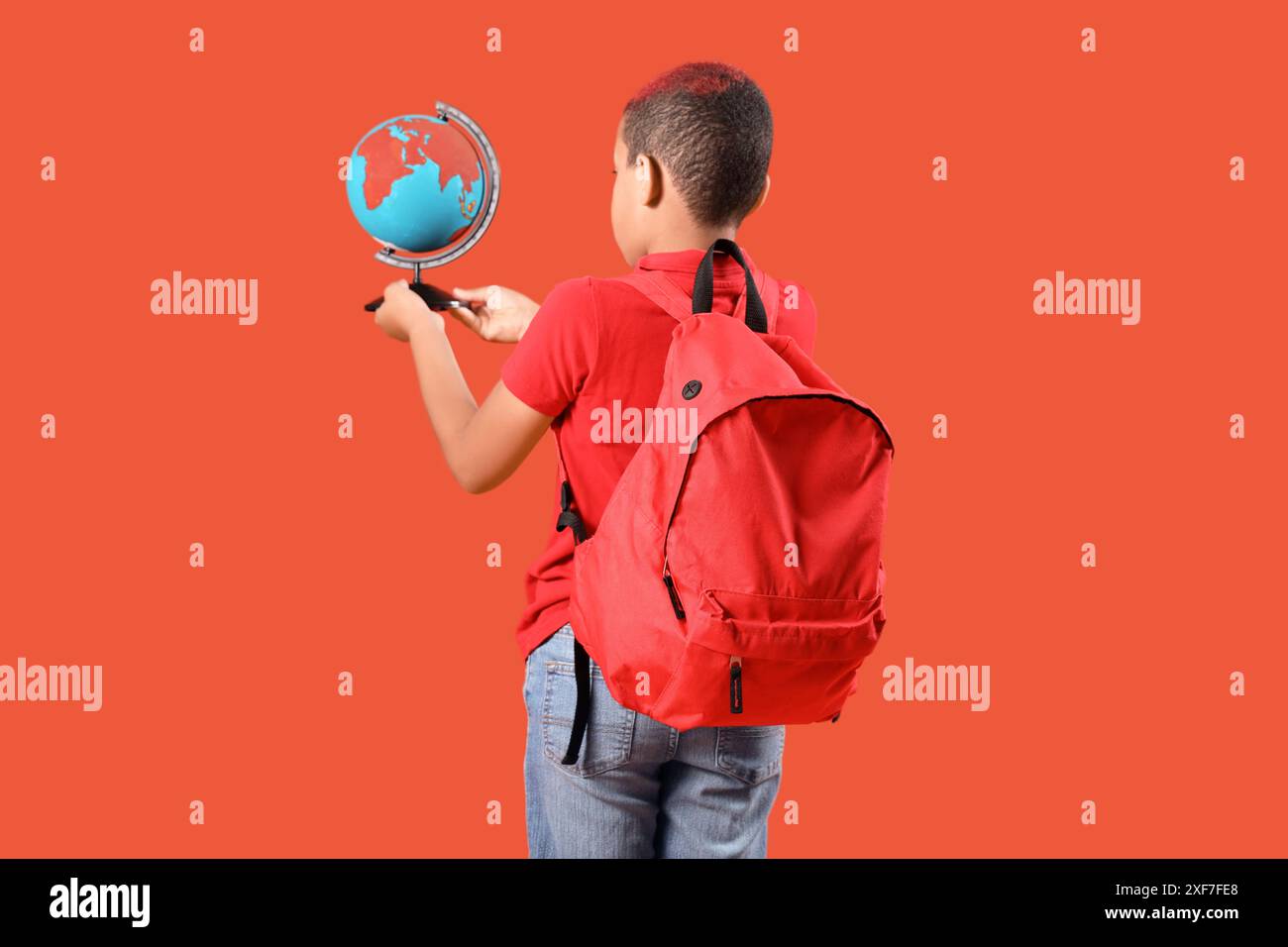 Little schoolboy with backpack and globe on orange background, back ...