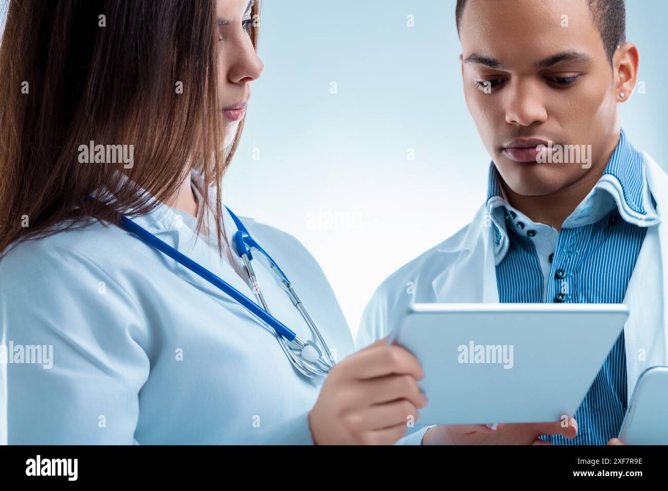 Two medical professionals collaborating on a digital tablet, focusing ...