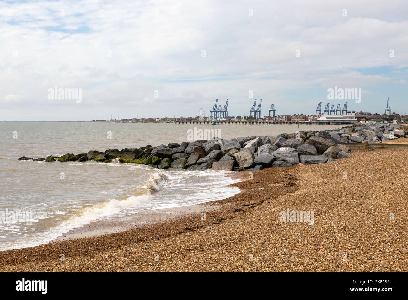 Rock armour groynes on beach managing longshore drift, Felixstowe, Suffolk, England, UK Stock Photo