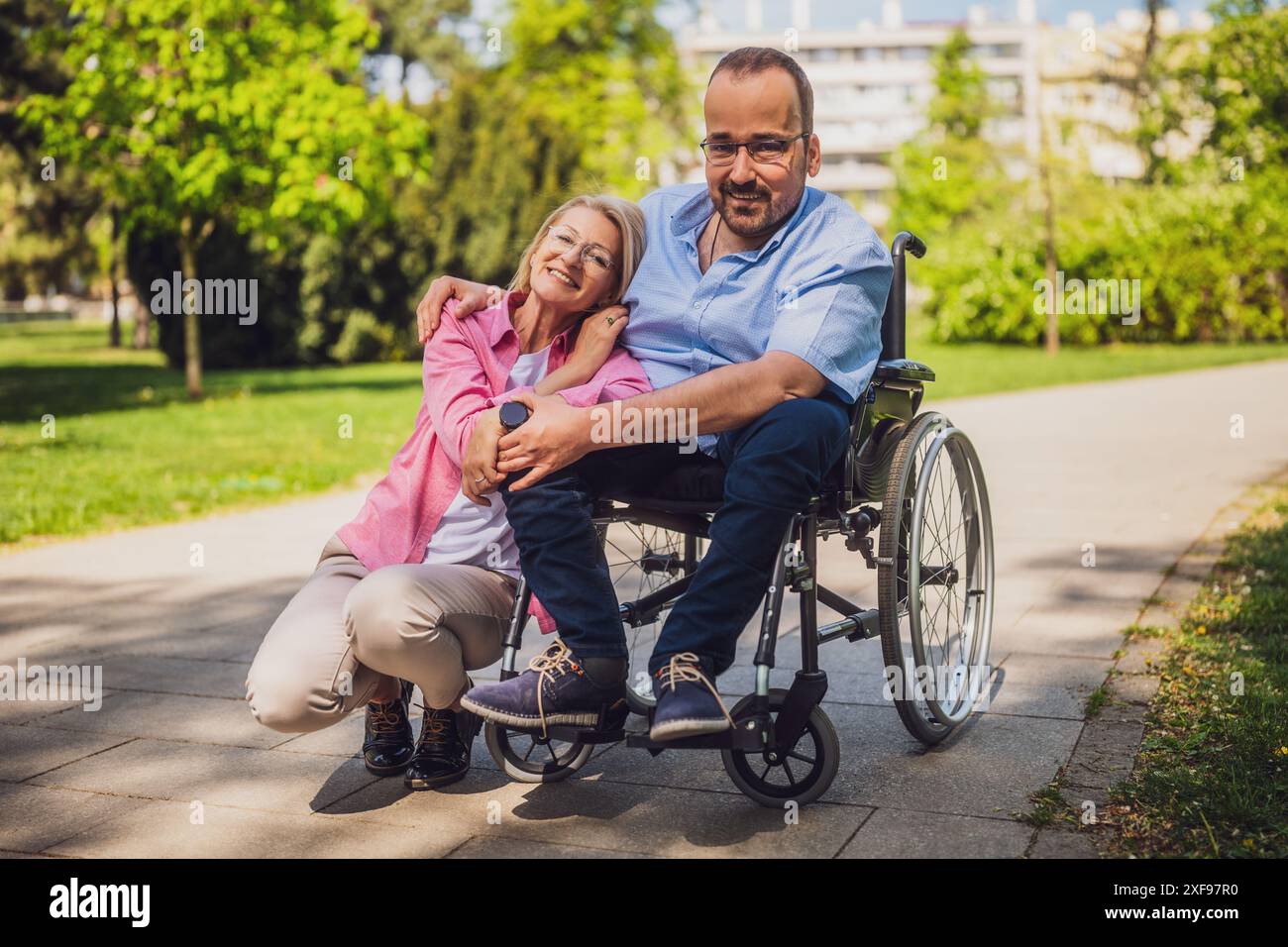 Man in wheelchair is spending time with his friend in park Stock Photo ...