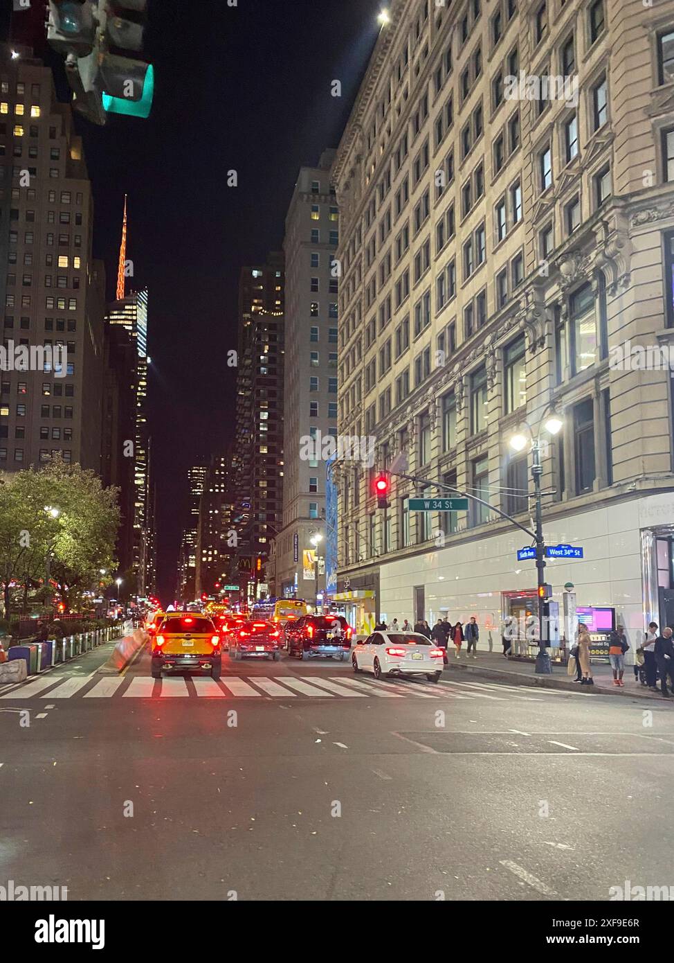 Street at night in a city with tall buildings, illuminated traffic ...