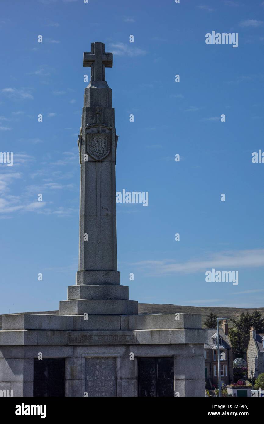 Imposing stone monument with a cross on top, against a clear blue sky ...