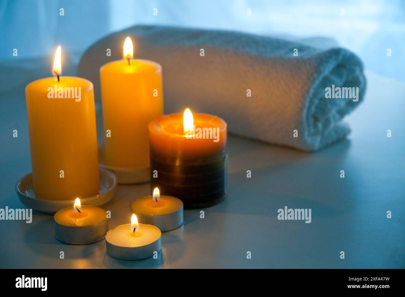 Lit up candles and towel. Stock Photo