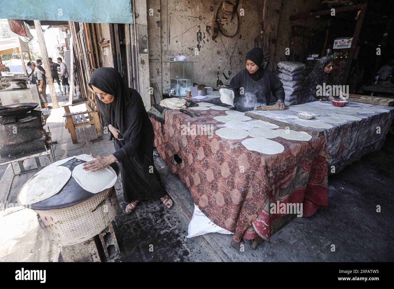 Palestinians women prepares flatbread dough at a stall kitchen in Deir ...